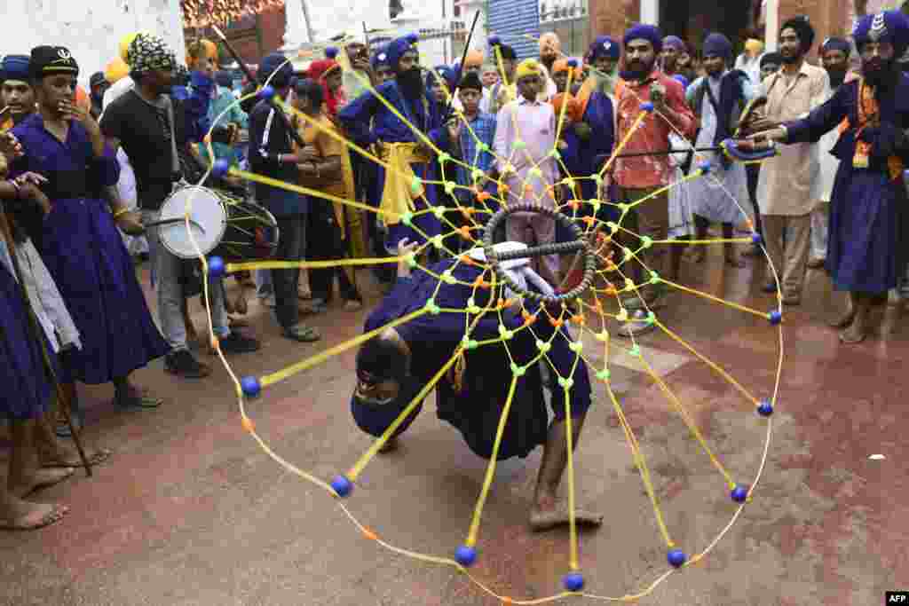 A youth performs the Sikh martial art known as 'Gatka' on the occasion of the 417th anniversary of the installation of the Guru Granth Sahib, at the Golden Temple in Amritsar, India.