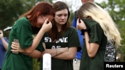 FILE - Mourners gather at a makeshift memorial left in memory of the victims killed in a shooting at Santa Fe High School in Santa Fe, Texas, May 21, 2018. 