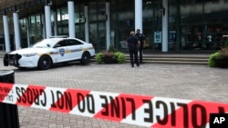 Jacksonville police officers guard an area, Aug. 27, 2018, near the scene of a fatal shooting at The Jacksonville Landing on Sunday in Jacksonville, Fla.