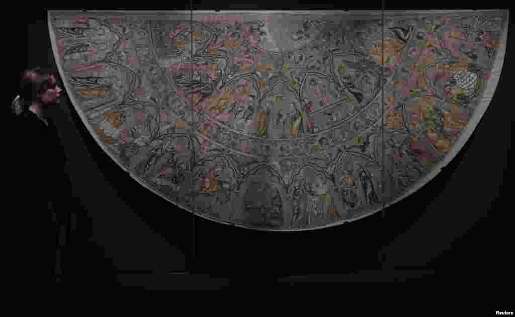 Seorang karyawan museum menatap Bologna Cope yang berasal dari abad ke-empatbelas yang membentuk satu koleksi besar dari potongan-potongan langka yang disatukan dari seluruh Eropa menjelang diselenggarakannya paemeran ‘Opus Anglicanum: Masterpieces of English Medieval Embroidery’ yang akan diselenggarakan di Museum Victoria dan Albert di London, Inggris.