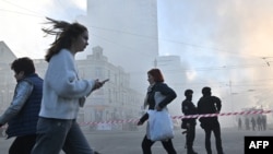 Residentes pasan junto a los agentes de policía después de un ataque con drones en Kiev el 17 de octubre de 2022, en medio de la invasión rusa de Ucrania.
