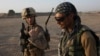 FILE - U.S. Marine 1st Lt. Zachary Bennett talks with an Afghan interpreter during a joint patrol in Helmand province, southern Afghanistan, Sept. 19, 2009. 