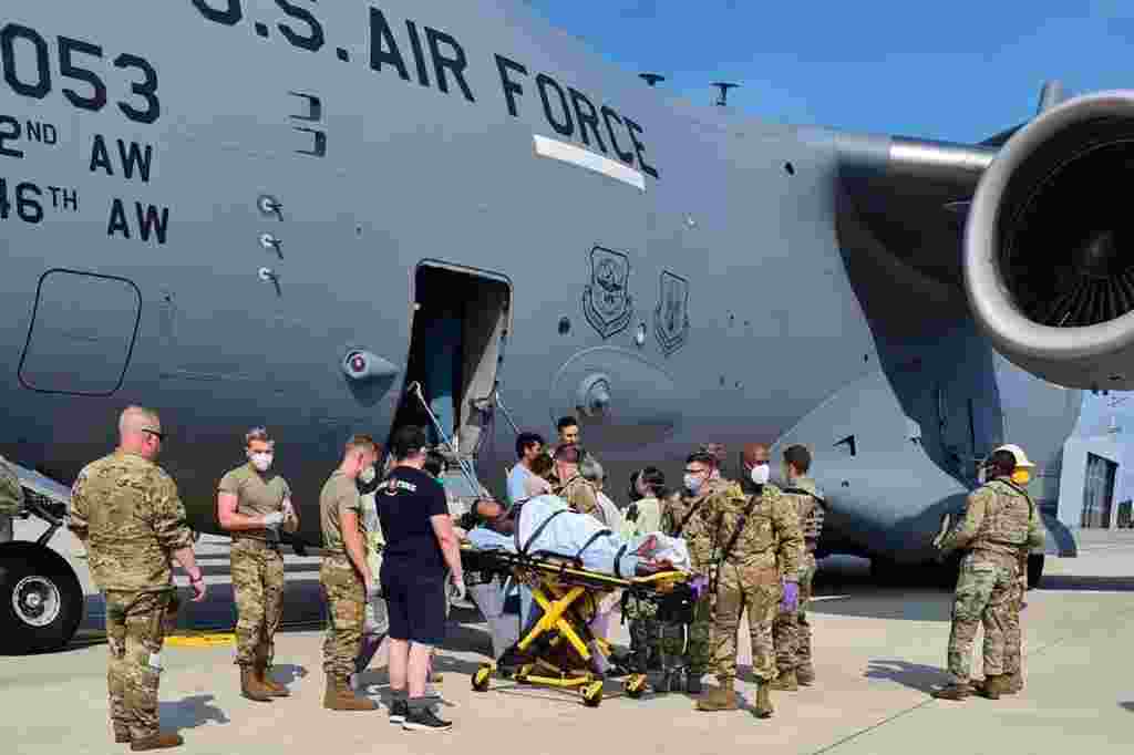Medical support personnel from the 86th Medical Group help an Afghan mother and family off a U.S. Air Force C-17 moments after she delivered a child aboard the aircraft upon landing at Ramstein Air Base, Germany, Aug. 21, 2021. (Credit: U.S. Air Force)