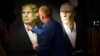 A journalist points at a portrait of U.S. President-elect Donald Trump, with a portrait of Russian President Vladimir Putin at right, during a live telecast of the U.S. presidential election in the Union Jack pub in Moscow, Russia, Nov. 9, 2016. 