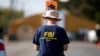 FILE - An FBI agent investigates the site of the shooting at the First Baptist Church of Sutherland Springs, Texas, Nov. 7, 2017. 