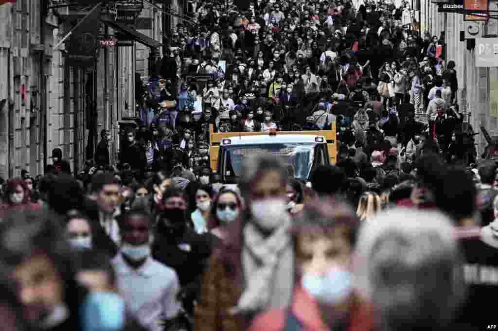 People walk in a crowded shopping street in Bordeaux, as cafes, restaurants and other businesses in France reopened after closures during the coronavirus pandemic.