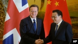 英國首相卡梅倫（左）和中國總理李克強12月2日在人民大會堂舉行聯合新聞發布會時握手