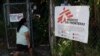 Una residente llega para una consulta médica en una clínica de la organización Médicos sin Fronteras (MSF) instalada en la comunidad del 1 de diciembre con un letrero que dice "Zona libre de armas".