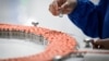 A staff member works during a media tour of a new factory built to produce a COVID-19 coronavirus vaccine at Sinovac, one of 11 Chinese companies approved to carry out clinical trials of potential coronavirus vaccines, in Beijing on September 24, 2020. (P