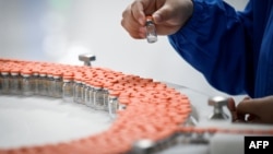 A staff member works during a media tour of a new factory built to produce a COVID-19 coronavirus vaccine at Sinovac, one of 11 Chinese companies approved to carry out clinical trials of potential coronavirus vaccines, in Beijing on September 24, 2020. (P