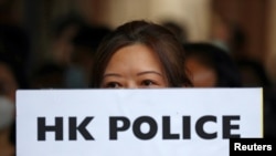 一名香港抗议者手举“香港警察大规模性犯罪”的牌子在中环遮打花园举行示威。（2019年10月11日）