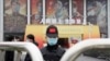 世界卫生组织团队于 2021年1月30日星期六抵达中国中部湖北省武汉市举行的抗击冠状病毒展览后，一名戴着口罩和带有中国国旗的帽子的保安人员守卫入口。