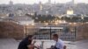 Palestinos se reúnen para romper su ayuno durante el mes sagrado musulmán del Ramadán, en el Monte de los Olivos con el telón de fondo de la Ciudad Vieja de Jerusalén y el recinto cerrado de la Mezquita al-Aqsa.