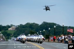 A military helicopter flies over a police escort on the Memorial Bridge, for motorcyclists riding in the 30th anniversary of the Rolling Thunder 'Ride for Freedom' demonstration in Washington, May 28, 2017.