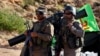 Hezbollah fighters stand on their army vehicle near the Lebanon-Syria border, July 29, 2017. 