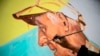 El artista peruano Daniel Manrique trabaja en un mural que representa a Lizardo Jiménez, de 80 años, víctima de COVID-19 en el cerro San Cristóbal en Lima el 15 de julio de 2020.