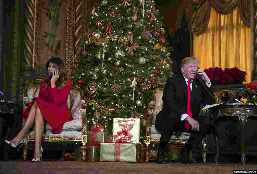 President Donald Trump and first lady Melania Trump speak on the phone with children as they track Santa Claus' movements with the North American Aerospace Defense Command (NORAD) Santa Tracker on Christmas Eve at the president's Mar-a-Lago estate in Palm Beach, Florida, Dec. 24, 2017.