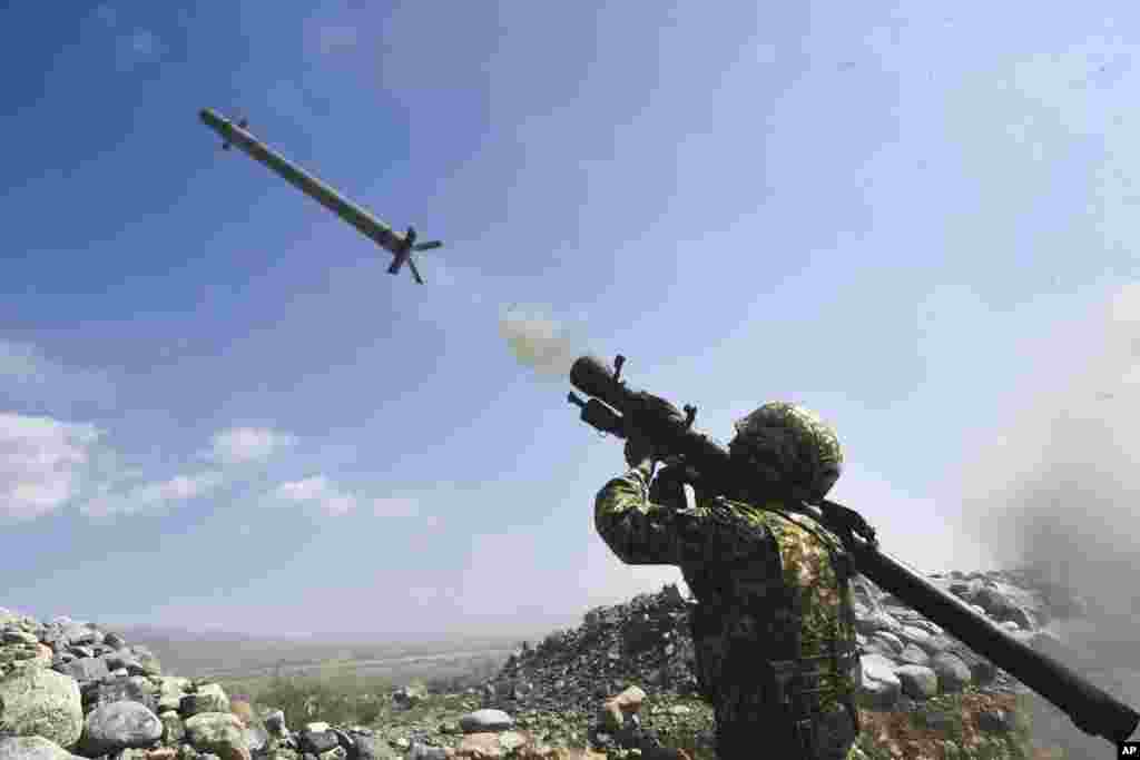 A Kyrgyzstan's soldier shoots from a portable air-defense system during a joint military exercises at the Edelweiss training ground, about 180 kilometers (113 miles) southeast of Bishkek.