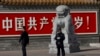 北京警察和便衣守在共产党万岁的巨幅标语墙前。(2013年11月7日) 