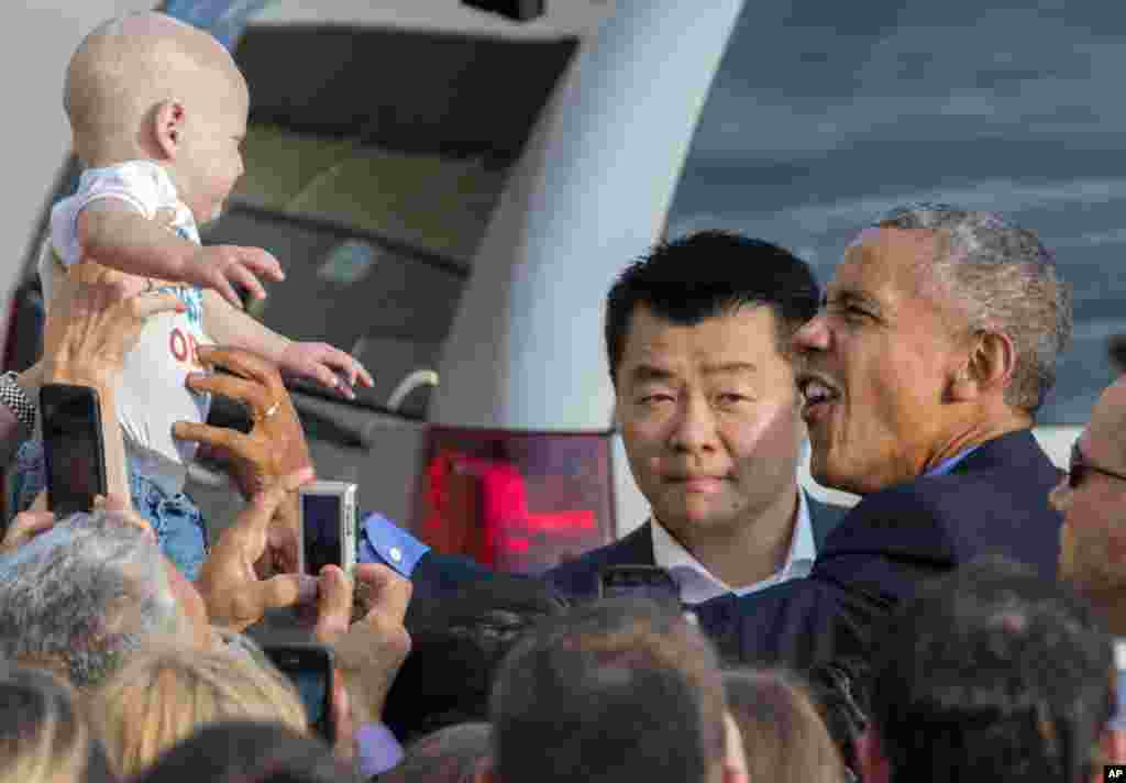 Presiden Barack Obama memeluk seorang bayi, Desmond Hatfield-Rudin (8 bulan) di antara kerumunan massa yang menyambutnya di bandara internasional John F. Kennedy, New York.