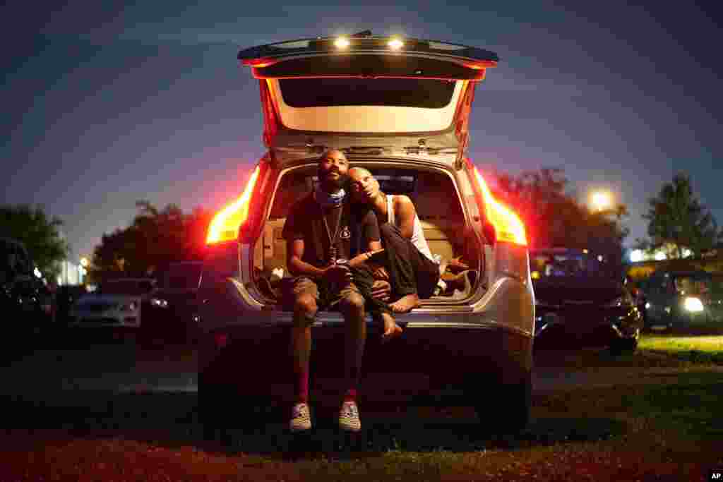 Kene Daniels, right, and Amman Raheem watch a documentary called "Rebuilding Black Wall Street," during a drive-in screening of documentaries during centennial commemorations of the Tulsa Race Massacre, May 26, 2021, in Tulsa, Oklahoma.