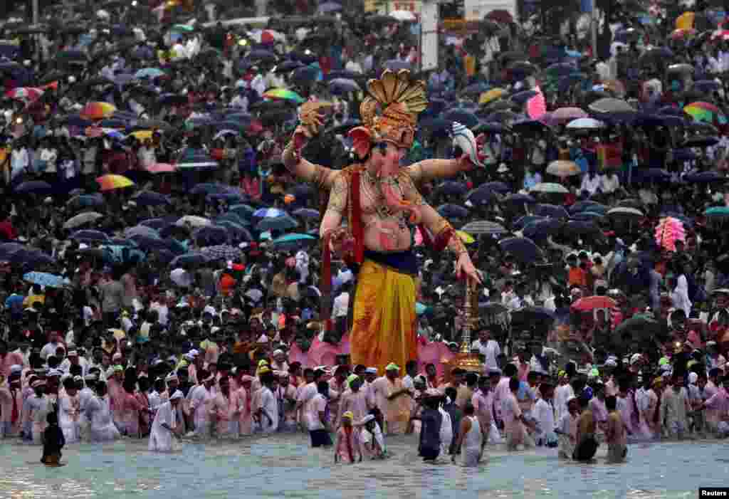 Ummat Hindu berkumpul di Laut Arabia untuk menceburkan patung Dewa Ganesha, Dewa Kemakmuran, pada festival keagamaan Chaturthi di Mumbai, India.