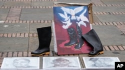 ARCHIVO - Objetos de personas que se presume que murieron en manos de las fuerzas de seguridad expuestas en la plaza de Bolívar durante una protesta contra las muertes de civiles en el estallido social de Colombia, en Bogotá, en agosto de 2021.