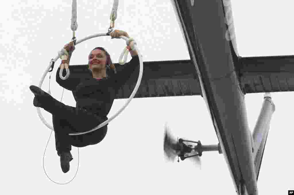 美国空中飞人埃伦迪拉·瓦伦达(Erendira Wallenda) 吊在直升机上表演杂技,在美国一侧飞越尼亚加拉瀑布(6月17日)