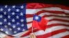 FILE - An anti-government protester holds a Taiwan national flag as a US flag flutters in the background during a demonstration to celebrate Taiwan's National Day in Hong Kong, China Oct. 10, 2019.
