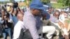 Uganda opposition leader Kizza Besigye being loaded into a police truck