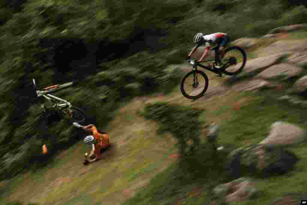 Mathieu van der Poel of the Netherlands tumbles on a downhill during the men's cross country mountain bike competition at the 2020 Summer Olympics in Izu, Japan.