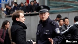 資料照：上海的警察盤查一位駐華外國記者。