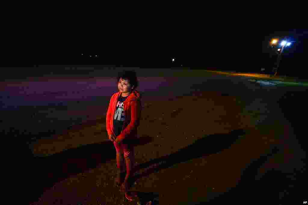 Emely, 8, of Honduras, stands alone after turning herself in upon crossing the U.S.-Mexico border, in La Joya, Texas. The unaccompanied child cried as she told her story of losing her guides and walking for miles with another group.