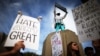 FILE - Protesters hold up signs during a march and rally against the election of Republican Donald Trump as president of the United States in Los Angeles, California, Nov. 12, 2016.
