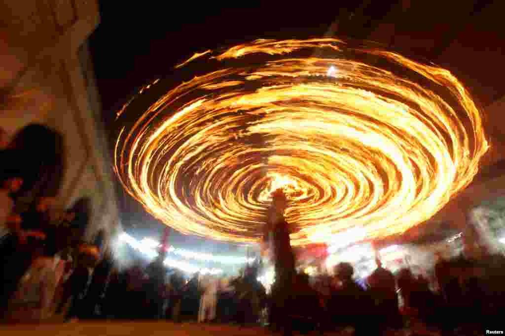 Shi'ite Muslims perform with fire during commemorations for Ashoura in Najaf, Iraq, Oct. 9, 2016.