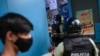 Miembros de la Policía Nacional ordenan al propietario de un negocio cerrar su tienda para frenar la propagación del COVID-19 en Caracas, el 21 de mayo de 2021.