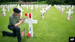 Mark Shively, from Beaverton, Oregon leaves flowers at the grave of his grandfather's unit commander, World War I U.S. Marine Corps Lt. Carleton Burr, during Memorial Day weekend at Aisne-Marne American Cemetery in Belleau, May 26, 2018.