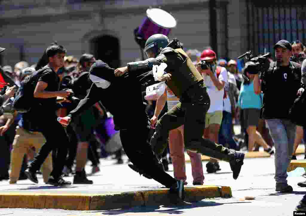 Para aktivis suku Indian Mapuche bentrok dengan polisi dalam aksi protes menentang perayaan Hari Columbus di Santiago, Chile.