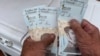 Un hombre sostiene los devaluados billetes venezolanos