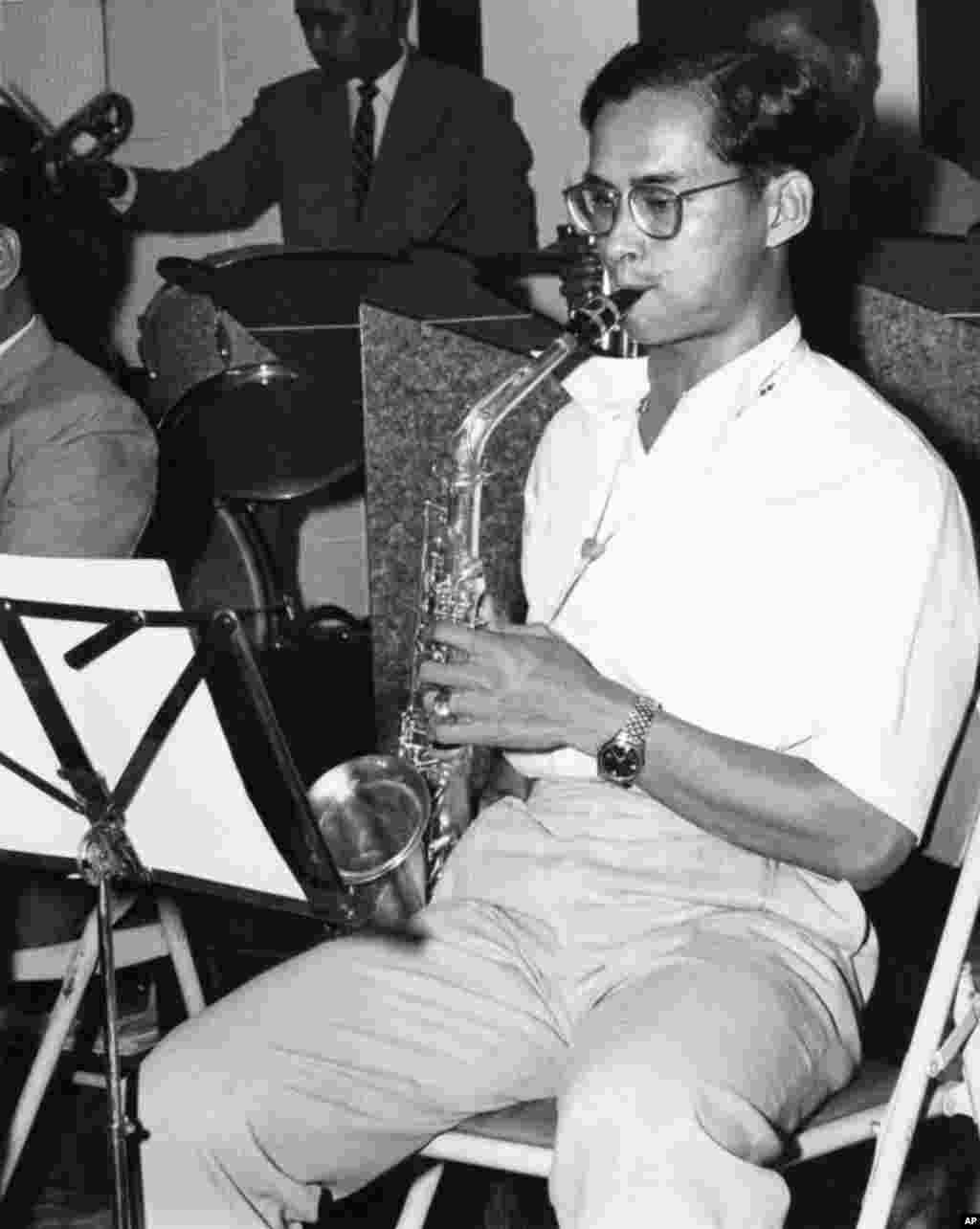 Raja Bhumibol Adulyadej memakai pakaian santai sambil main saksofon bersama band jazz beranggotakan 13 orang, 1962.