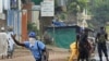 Guinean police carrying automatic weapons clear the mostly Peul suburb of Bambeto in Conakry, Guinea, Tuesday, Nov. 16, 2010, as groups of UFDG youth set up barricades. A de-facto curfew is in effect in the area, residents staying inside, one day after it