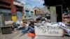 Un manifestante antigubernamental empuja un refrigerador para hacer una barricada en Caracas.