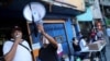 Voluntarios utilizan un megáfono cerca de un centro de votación para la consulta popular destinada a rechazar las elecciones parlamentarias del 6 de diciembre en el barrio de bajos ingresos de La Cruz en Caracas. Diciembre 12, 2020.