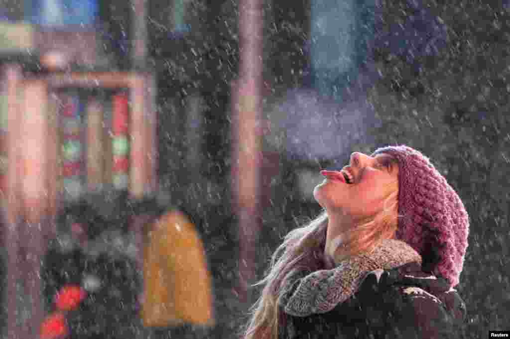Uma turista apanha flocos de neve com a língua na Times Square, Nova Iorque, Jan. 2, 2014.