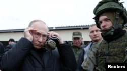 El presidente ruso, Vladimir Putin, se ajusta las gafas durante una inspección de las prácticas de tiro de los reservistas movilizados, en la región de Ryazan, en Rusia, el 20 de octubre de 2022.