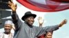 Nigerian President Goodluck Jonathan (C), accompanied by his wife Patience (R), Vice President Namadi Sambo, waves to the crowd before their campaign declaration in Abuja on September 18, 2010.