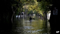 ARCHIVO - Un hombre rema en una embarcación por una calle inundada debido al aumento del nivel del agua del Río de la Plata, en Tigre, en las afueras de Buenos Aires, Argentina, el 21 de marzo de 2024.