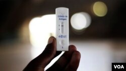 A man holds a Covid-19 testing kit at a private health facility in Harare, Zimbabwe, Thursday, Feb, 3, 2022. African nations have very limited access to COVID-19 tests, especially at-home tests. (AP)