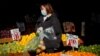 ARCHIVO - Una mujer compra frutas en un mercado al aire libre en Brooklyn, Nueva York.