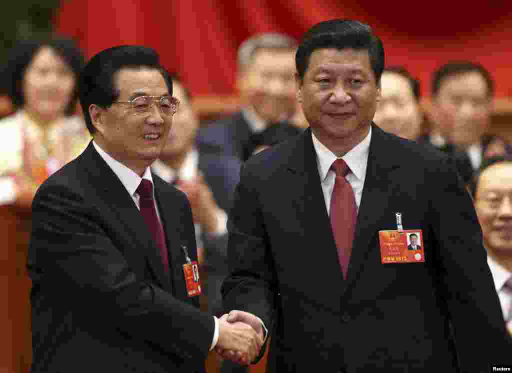 Mantan Presiden China Hu Jintao (kiri) bersalaman dengan penggantinya, Xi Jinping, dalam sidang paripurna Kongres Nasional Rakyat China ke-12 di di Beijing (14/3).